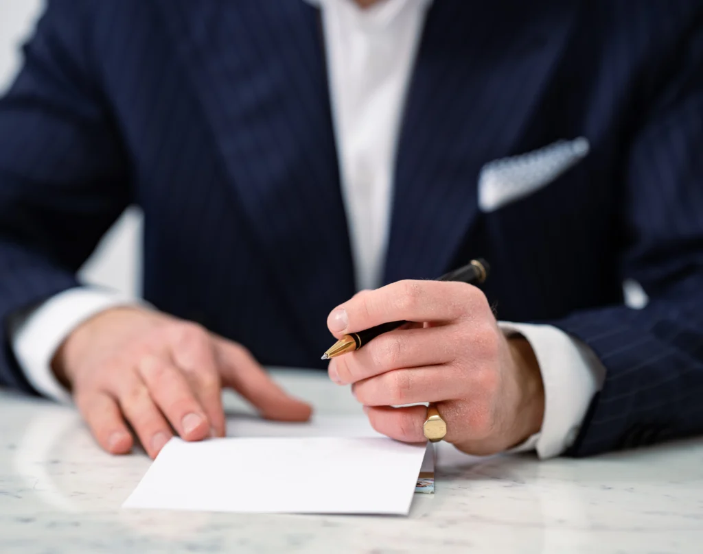 Meno Peemöller mit einem Kugelschreiber in der Hand und notiert Vor- und Nachteile zum Hausverkauf ohne Makler.